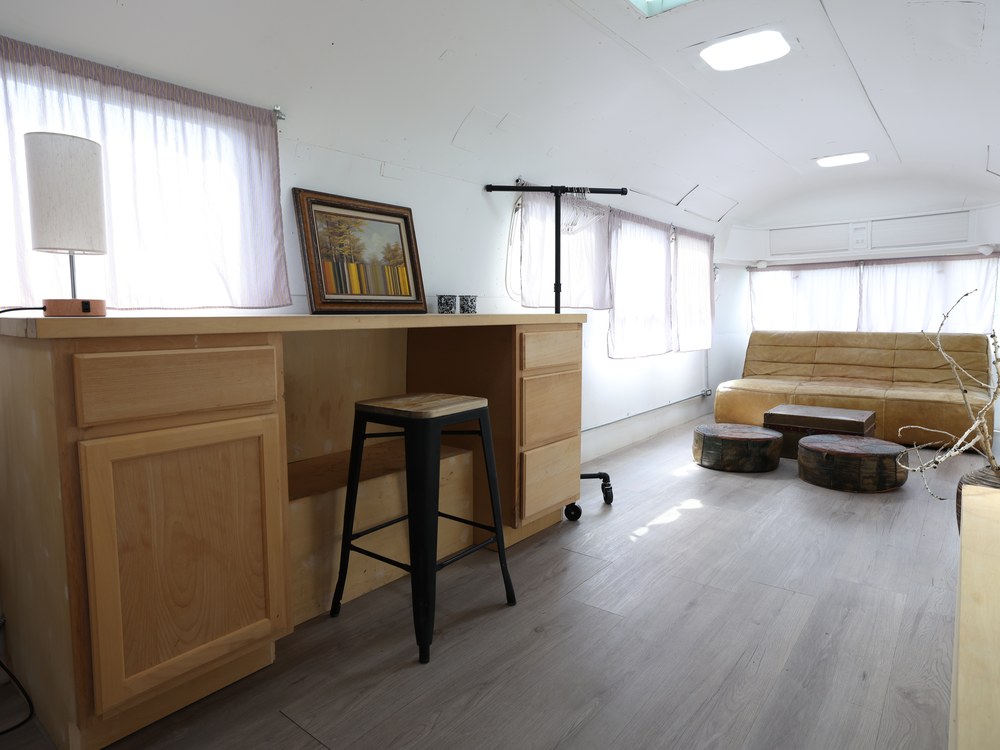 Airstream interior with desk, stool, and lounge seating