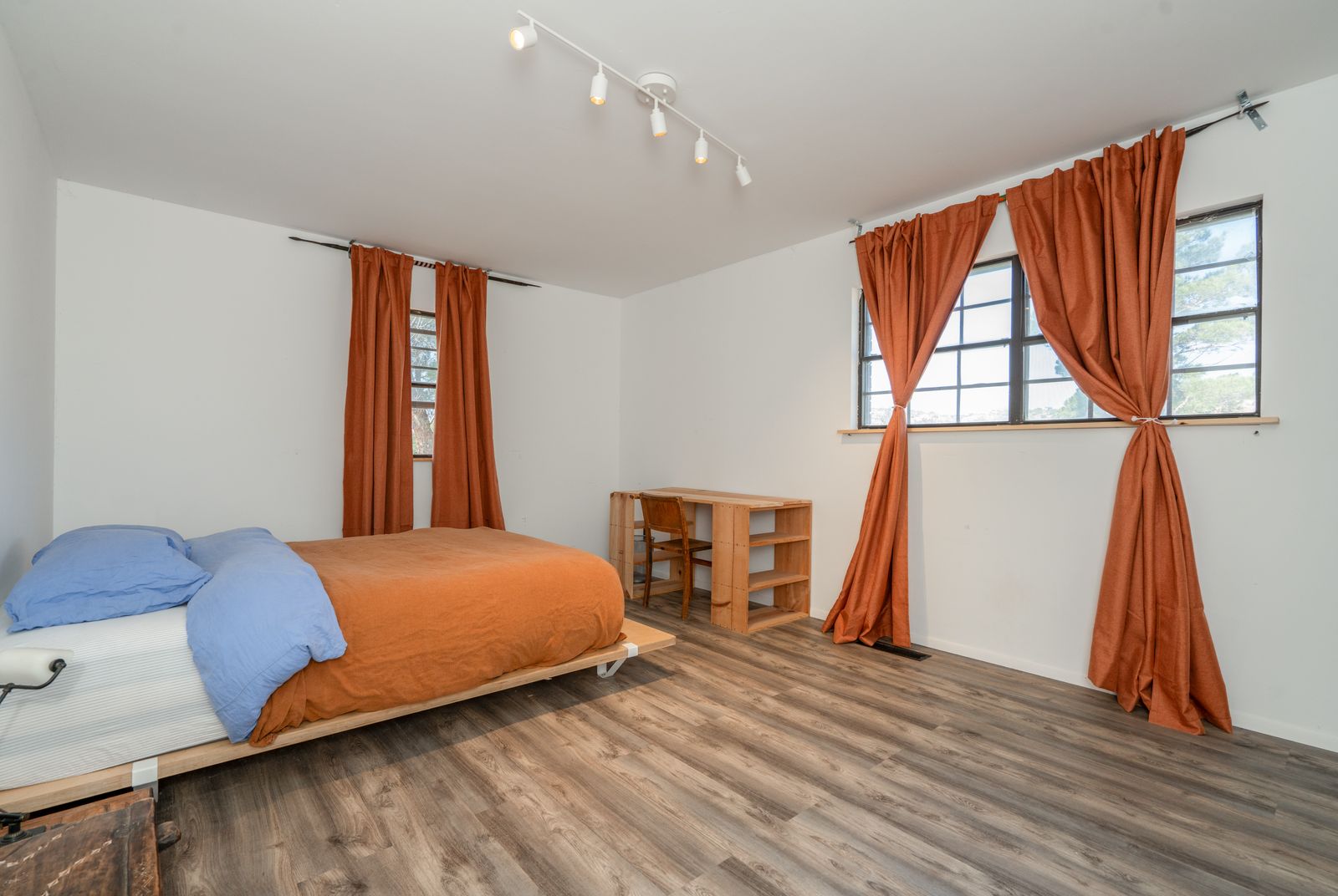 Bedroom with platform bed and desert-orange curtains