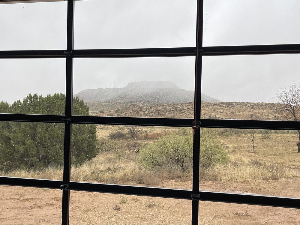View from studio through glass garage door at desert mesa